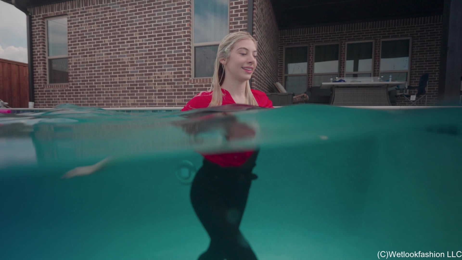 Amber Enjoys the Pool Wearing Black Pants and a Red Shirt
