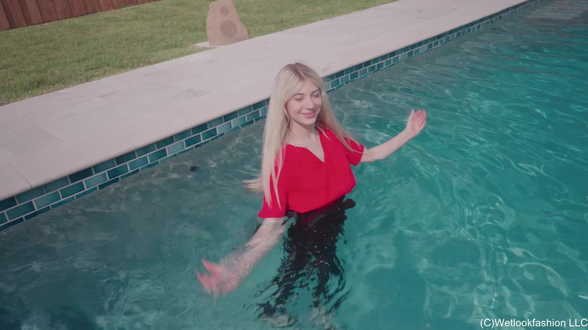 Amber Enjoys the Pool Wearing Black Pants and a Red Shirt