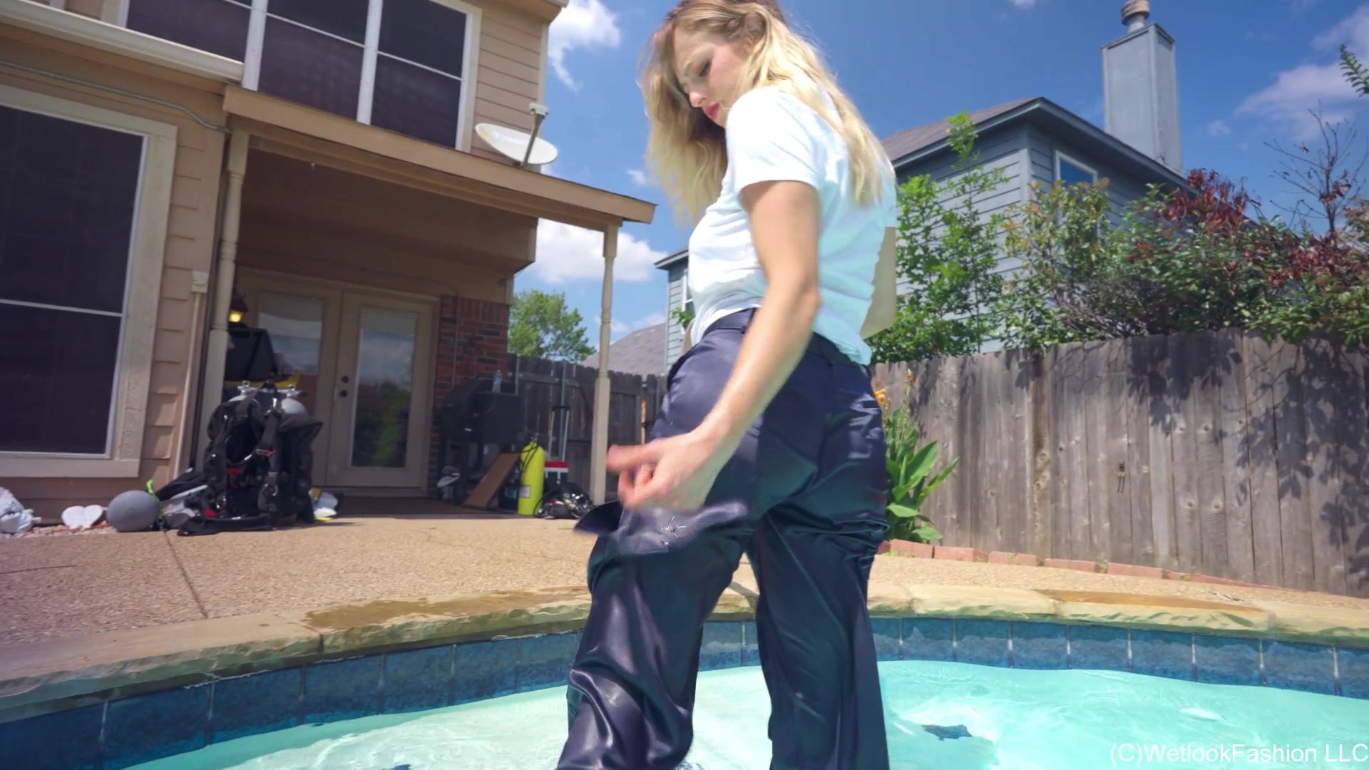 Camille schwimmt in einem weißen Hemd und einer blauen Satinhose