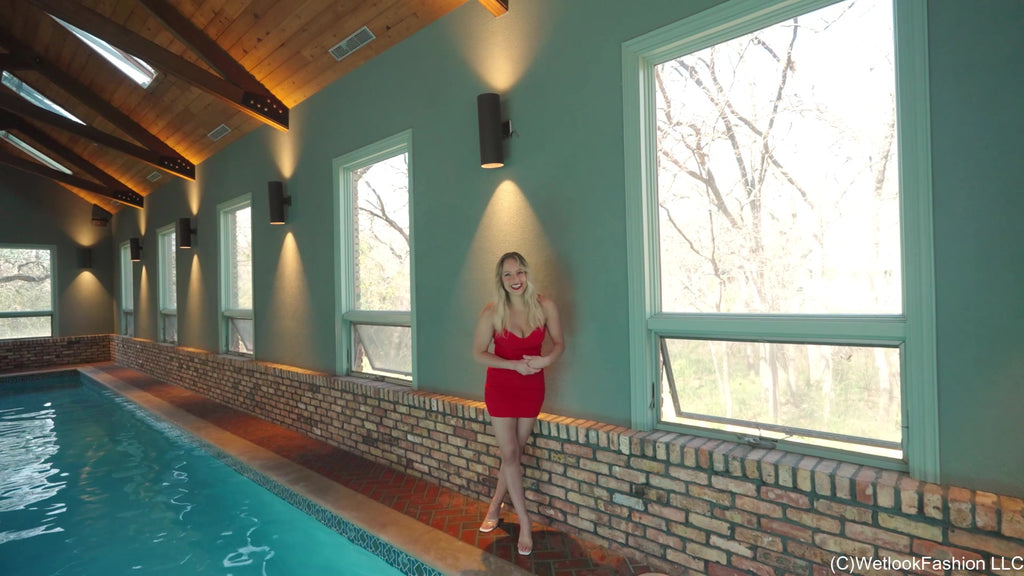 Camille trägt ein kurzes rotes Kleid im Pool