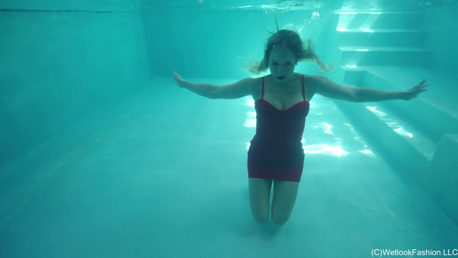 Camille wears a Short Red Dress in the Pool