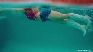 Cowgirl Brinley geht mit Stiefeln und Shorts schwimmen