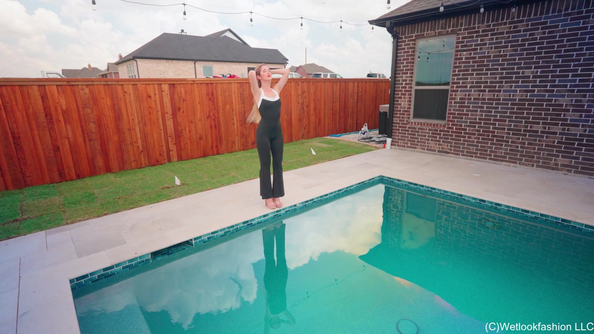 Kate taucht im Pool in einem schwarzen, glänzenden Jumpsuit