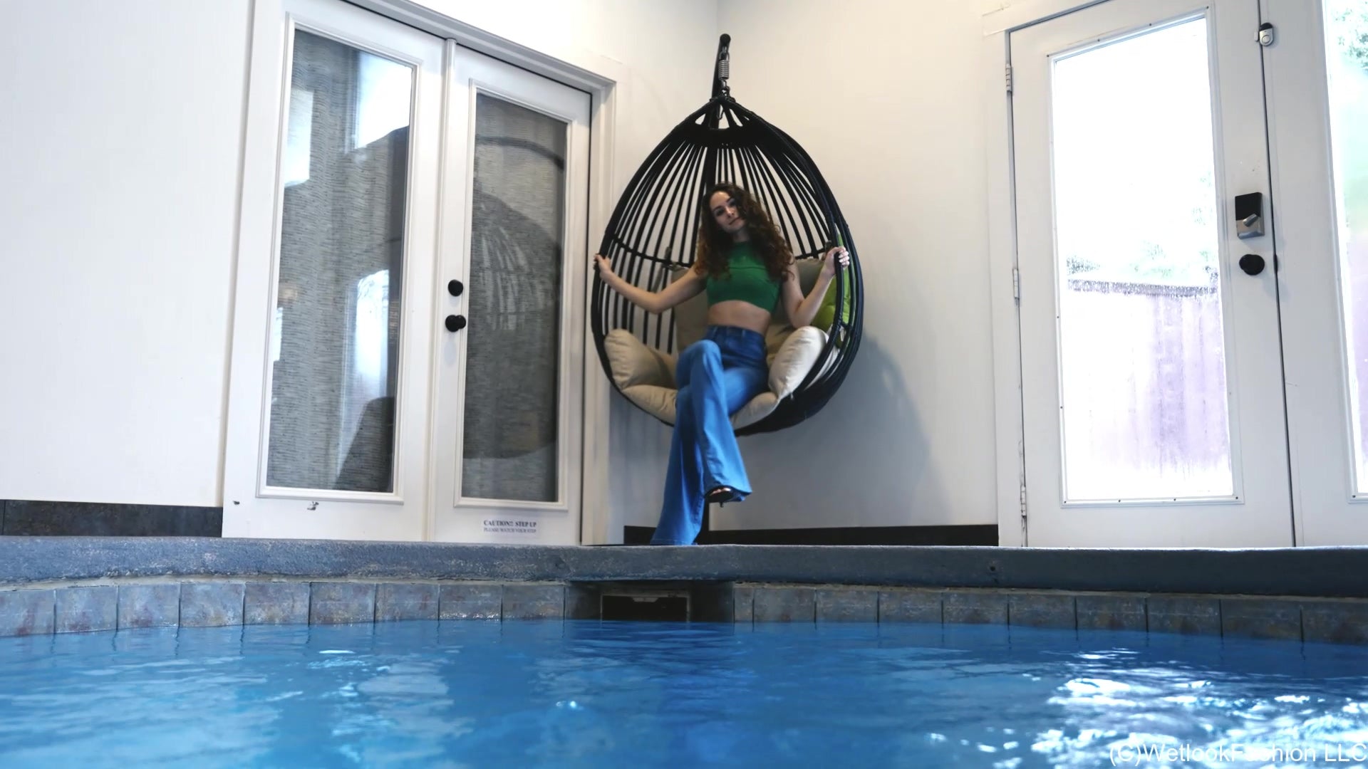 Lilith Swims in Flared Blue Jeans, Crop Top and High Heels