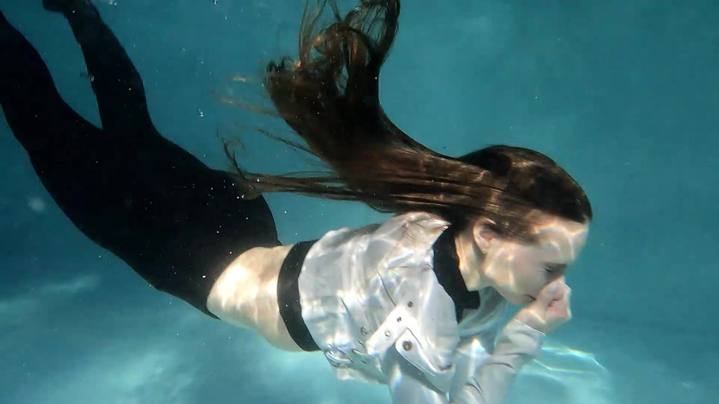 Lilith schwimmt in Leggings, Stiefeln und Lederjacke