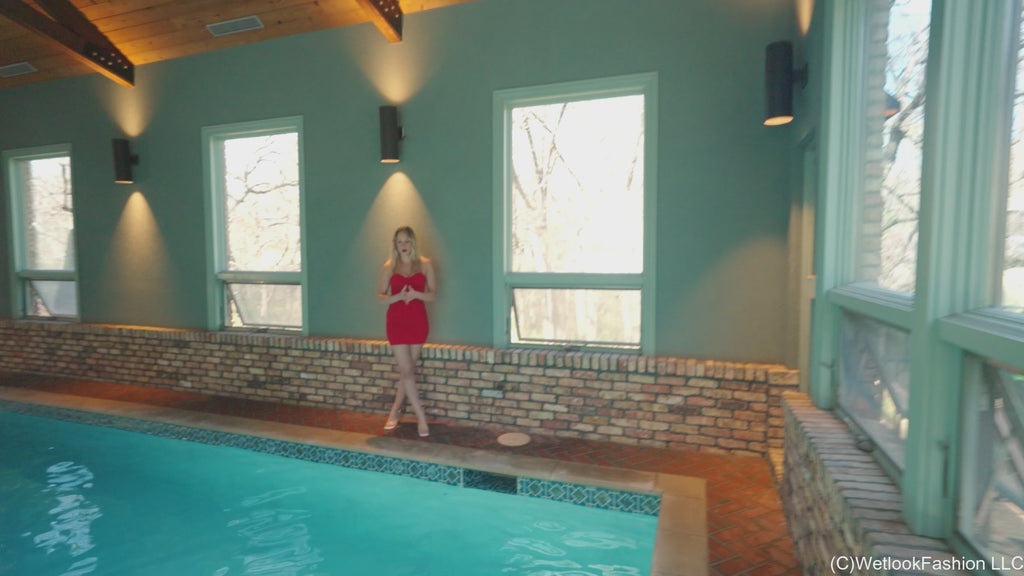 Camille trägt ein kurzes rotes Kleid im Pool