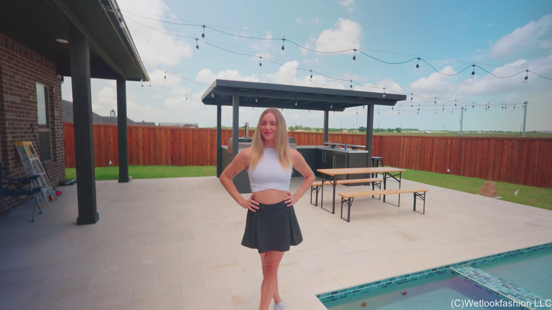 Victoria schwimmt im Pool in sportlichem Rock und Top.