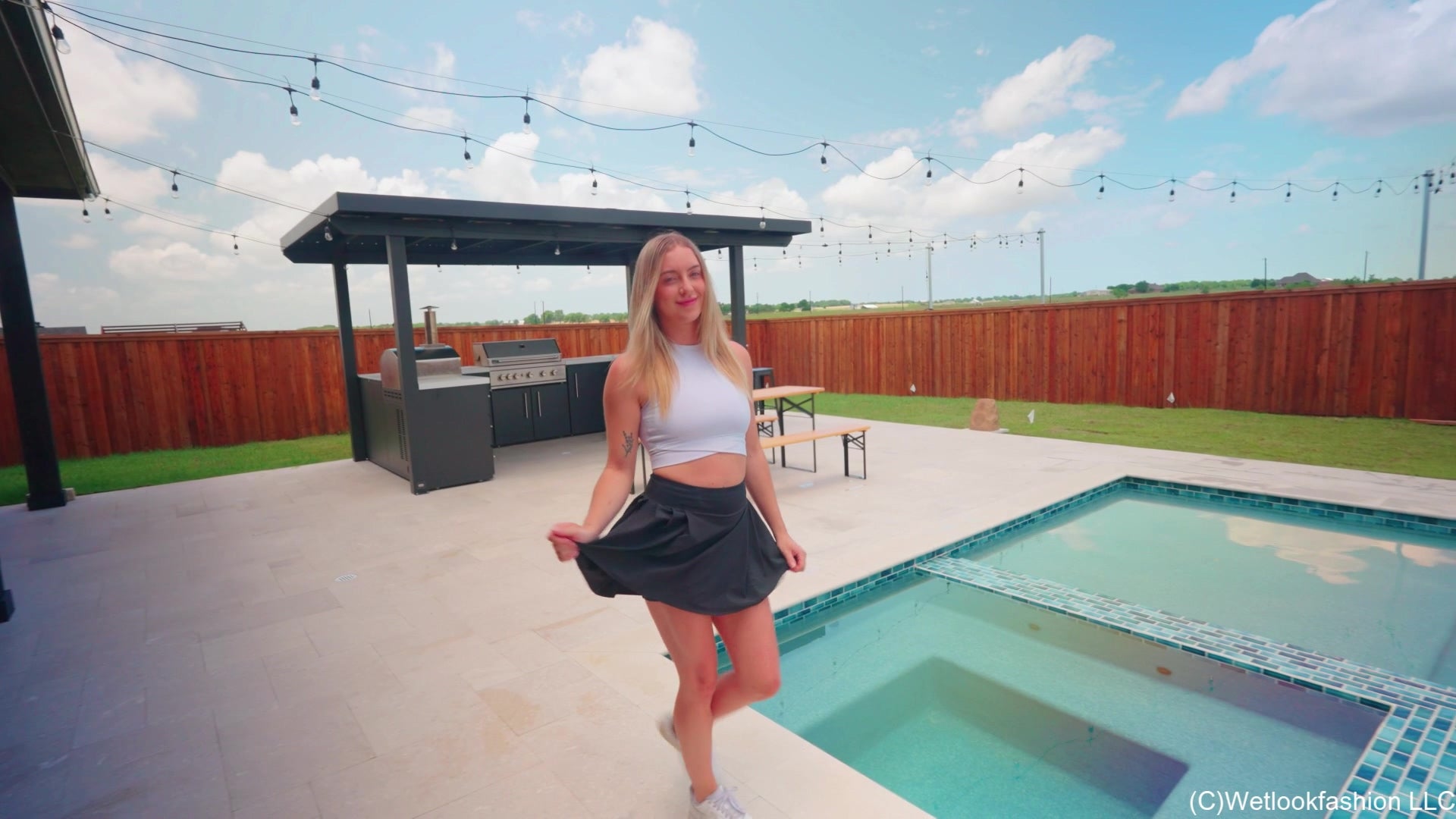 Victoria schwimmt im Pool in sportlichem Rock und Top.